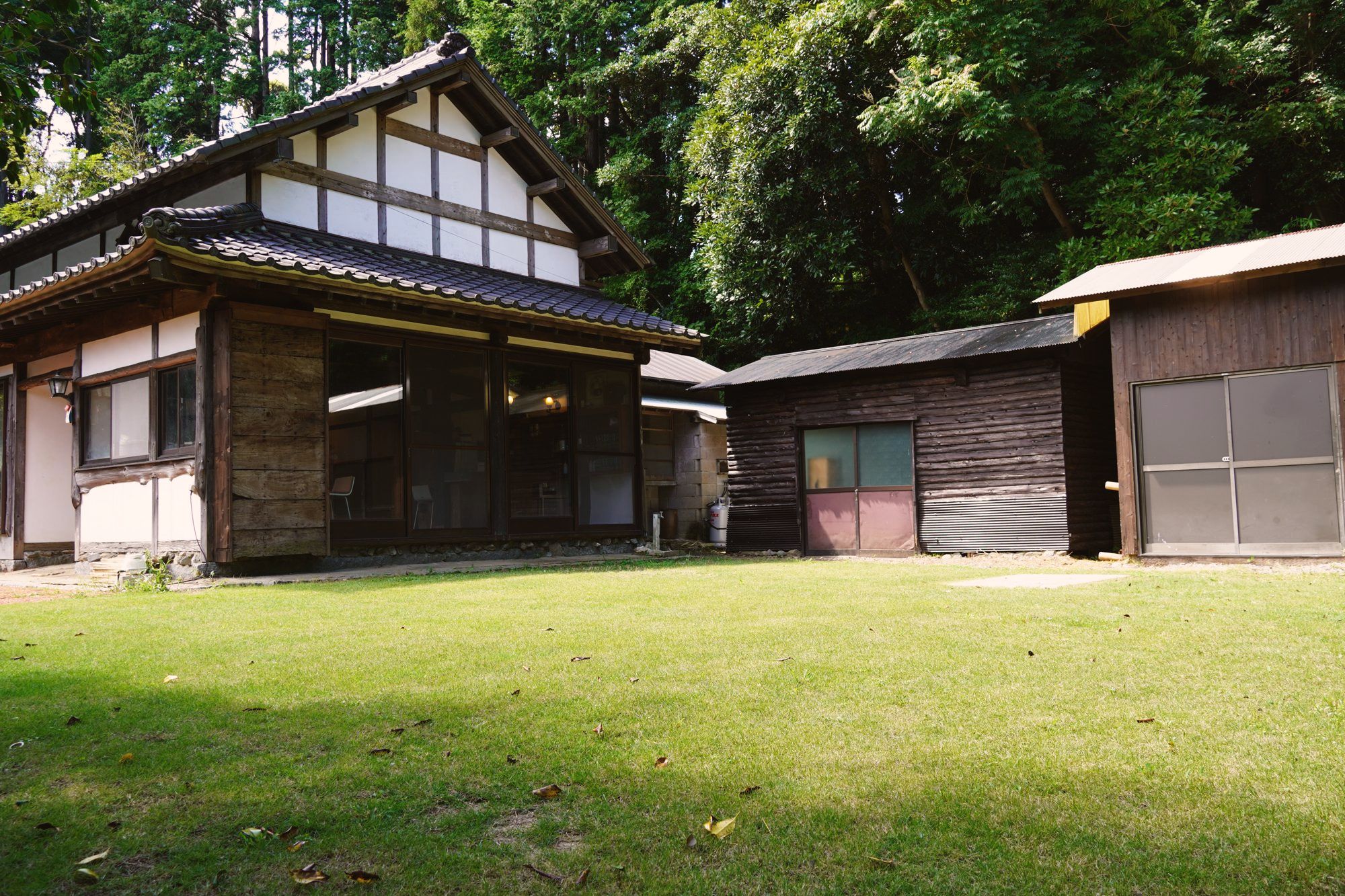 芝生の庭と、築150年を超える古民家 TSUBAKIhouse の外観